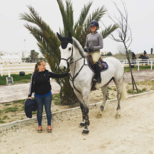 En person på en häst och till person fångas på bild framför en palm
